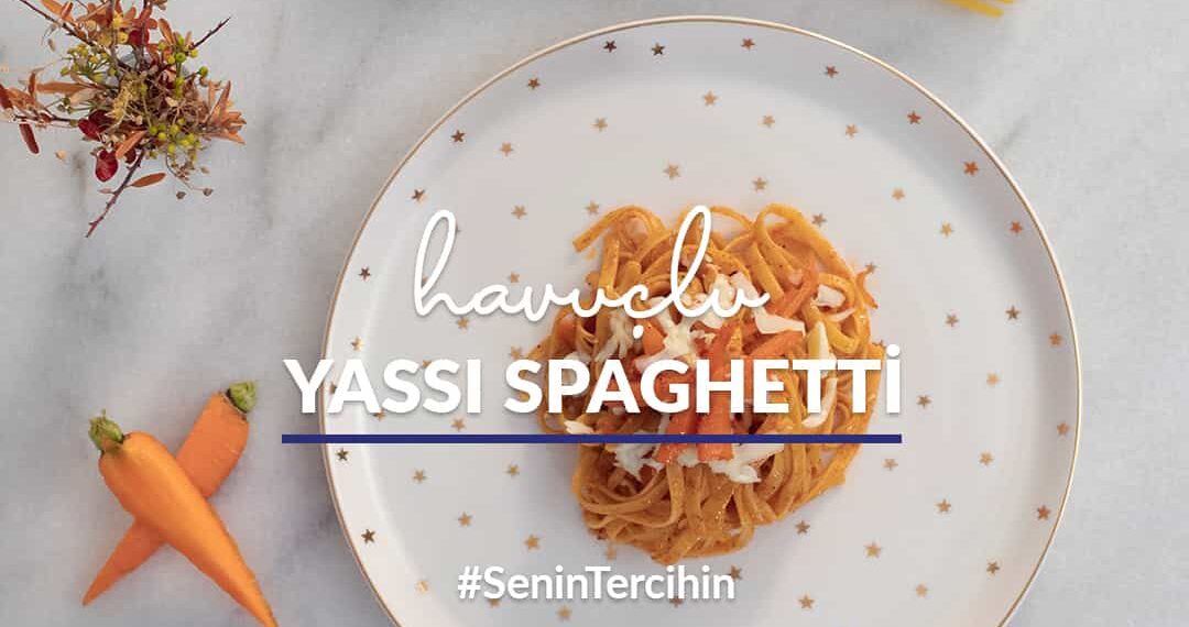 Mermer tezgah üstünde yer alan tabakta havuçlu yassı spaghetti; çevresinde kurutulmuş çiçek, dilimlenmiş havuç ve pişirilmemiş yassı spaghetti