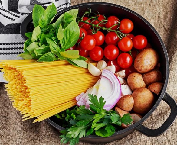 bir tencerenin içerisinde spaghetti makarna, maydanoz, nane, soğan, sarımsak, domates ve patates yer almaktadır.