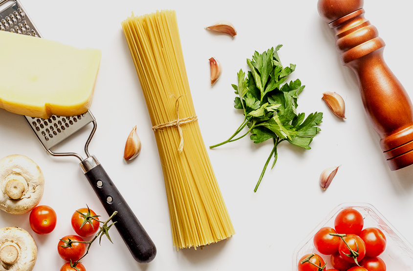 Masanın üzerindeki spaghetti domates yeşillik sarımsak ve peynir