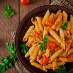 tabağın içerisindeki penne makarna domates ve yeşillik