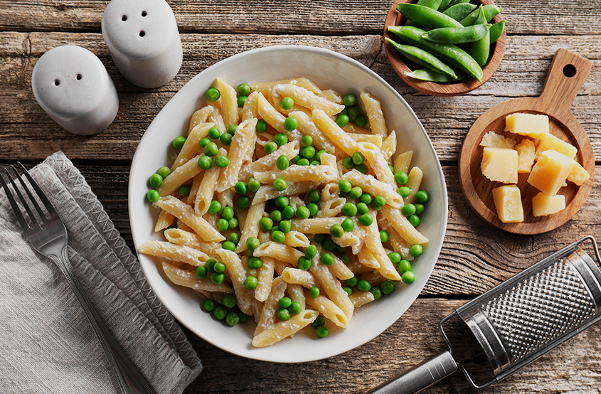 Tabağın içerisindeki penne makarna ve bezelyeler