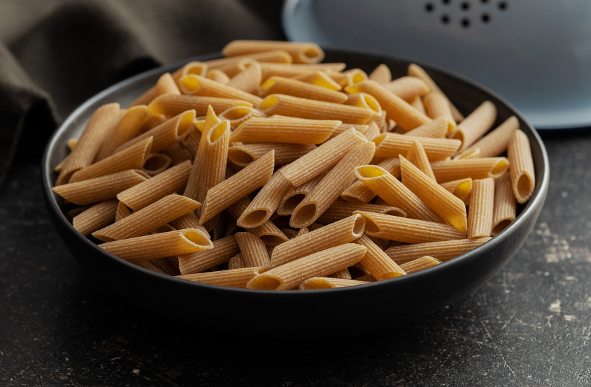 tabağın içerisindeki pişmemiş tam buğday penne